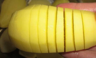 Using a sharp knife, we make accordion-shaped cuts on each potato, but do not cut all the way through so that the tuber remains intact at the base. For convenience, you can place the potato in a tablespoon and cut it on top - the edges of the spoon will not allow you to cut the potato to the end. Sprinkle each potato with salt and ground black pepper to taste.