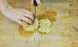 Bahan seterusnya ialah nanas. Buka balang dan tuangkan jus ke dalam mana-mana bekas. Jangan tuangkan cecair ke dalam singki: jus daripada nanas dalam tin adalah lazat dan menyegarkan. Keluarkan nanas dari balang dan potong saiz yang sama dengan isi ayam.