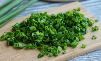 Wash a bunch of green onions with cold tap water, shake well and cut into small rings. 