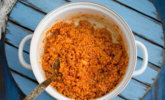 When the garlic begins to release its aroma, add tomato paste and stir. Next, add the red lentils and mix everything thoroughly again.