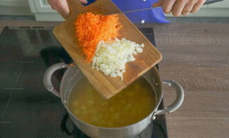 Peel one carrot, wash it and grate it on a coarse grater. We also peel the onions and finely chop them with a knife. Place the prepared vegetables in a saucepan with the potatoes and peas, then add salt and ground black pepper to taste.