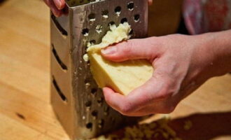 Grate a piece of cheese on a grater with large holes. If you wish, you can grind the cheese on a finer grater.