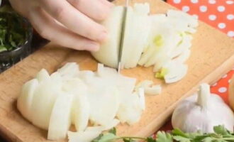 Let's start sautéing. Peel the onions and cut them into half rings.