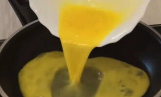 Heat two tablespoons of vegetable oil in a frying pan and pour in the egg mixture, give a little time for the egg to set. 