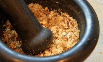 Grind the walnuts in a mortar or chop them very finely with a knife.