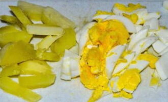 Boil the potatoes and eggs in advance. We clean the products and also cut them into smaller pieces.