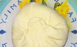 Next, we gather the edges of the dough, pinch them tightly and roll everything out again into thin flat cakes of 3-5 mm.