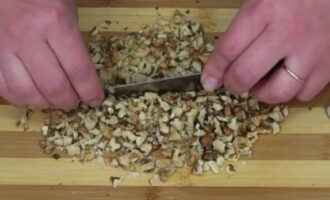 Crack the walnuts and remove the edible part from the shell. We wash the nuts and place them on a paper towel to absorb excess moisture. Finely chop the product.