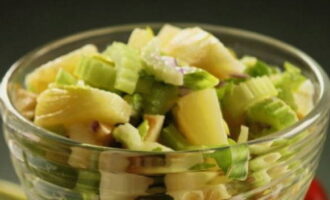 Now we take a suitable salad bowl and put chopped celery, apples, and most of the chopped walnuts there.