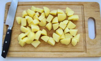 Wash the potatoes with running water and cut off the skins with a knife. Rinse the root vegetables again and cut into large pieces. Place the potatoes in the pan with the ribs and vegetables. If there is not enough liquid in the container, add a little more water.