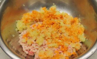 Peel the onion and carrots, rinse the root vegetable with running water and cut both products into large pieces. Then we pass them through a meat grinder directly into a bowl of minced meat.