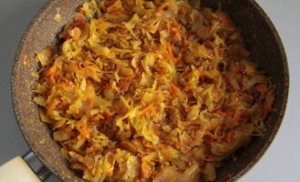 Place sauerkraut in a container. Season the mixture with salt, sugar and ground black pepper. Add tomato paste and fry the ingredients for 25 minutes, stirring constantly.