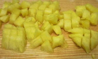 Drain the syrup from a can of canned pineapple and cut the fruit into small cubes.