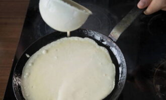 Now we bake thin pancakes, greasing the pan with a small amount of vegetable oil from time to time. Brown them on one side only, but the other side should be completely dry. Place the finished pancakes in a stack on a plate. 