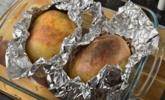 Open the oven and take out a baking sheet with potatoes. Open the foil and place the potatoes back in the oven for 10 minutes. Raise the temperature to 200 degrees. 