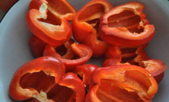 Now let's prepare the peppers for stuffing. To fill it with filling, you must first wash all the fruits, wipe dry with a towel and cut in half. Then remove the seed box and stalk. Fill the pepper halves with minced meat.