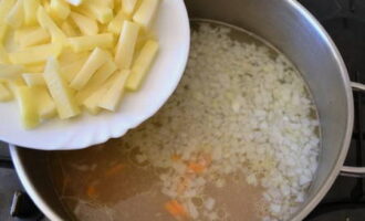 Após o tempo necessário, retire o frango do caldo e acrescente a cebola picada, a cenoura e a batata.