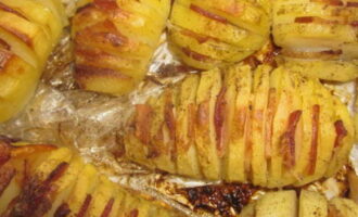 Transfer the finished rosy accordion potatoes to a dish and serve hot. Sprinkle herbs on top to taste.