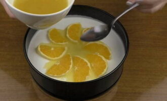 Cortar la naranja lavada en rodajas (no demasiado finas). Retire la piel de las rodajas y córtelas por la mitad.Calentar el jugo de naranja y disolver en él el resto de la gelatina. Sacamos del frigorífico el molde con la preparación y decoramos la tarta de queso con naranjas. Viértelos con una pequeña cantidad de la mezcla de jugo y gelatina.