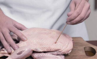 How to bake duck with rice in the oven? Wash the bird carcass well, remove fat from the neck and tail area. Prick the carcass on all sides with a toothpick or skewer, pour boiling water over it and hang for an hour.