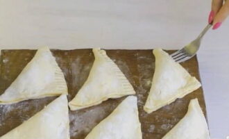 Pour a small amount of flour into a small saucer. Take a fork and place its tines into the flour. We apply the floured teeth to the edges of the pies, thus forming a beautiful pattern.