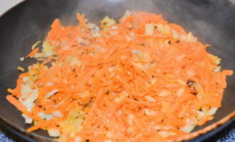 Grind the peeled and washed carrots on a coarse grater, and then transfer them to another deep bowl. Heat the remaining vegetable oil in a frying pan and add the onion. Fry it, stirring constantly with a spatula. Add carrots. Fry the vegetables until golden brown.