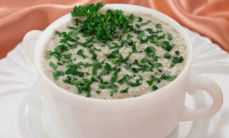 Pour the cream of mushroom soup into bowls and serve it to the table, garnished with herbs.