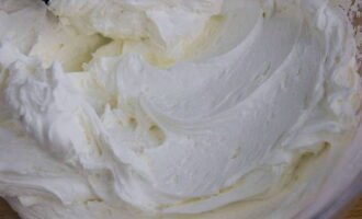 Chilled cream is whipped to stiff peaks and then mixed with cheese using a mixer.