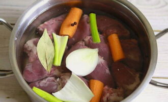 Place the hearts in a saucepan, cover them with water and bring to a boil. Also add an onion, one carrot, celery, bay leaf and peppercorns to the water. Cook everything together for 1-1.5 hours over medium heat.