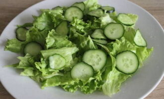 Cut the cucumber into thin slices and place on top of lettuce leaves.