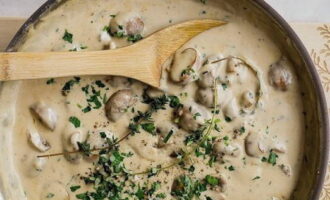 Los champiñones con cebolla se vierten con crema y se cuecen a fuego lento durante 15-20 minutos para que la salsa se evapore un poco y se espese. 