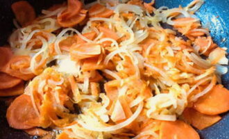 Peel the onions and carrots and rinse under running water. Cut the carrots into thin slices, cut the onion into half rings. Place the frying pan on the fire, pour in the vegetable oil. First, fry the onion for about 3 minutes, stirring constantly. Next, add the carrots and continue to fry until the carrots are soft.