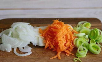 Chop the second part of the vegetables. Cut the onion into half rings, grate the carrots, cut the leek into rings.