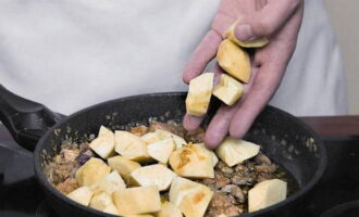 Next, add coarsely chopped liver to the pan and fry it for 1 minute. Peel the apples, cut them into cubes and place them on the liver along with boiled rice. Stir the contents of the pan, add salt, ground pepper, a pinch of ginger powder and cinnamon.