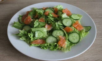 Potong fillet ikan trout menjadi kepingan kecil dan letakkannya selepas timun di atas pinggan.