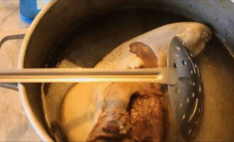 After 20 minutes, pour very cold water into a separate deep bowl and add a few ice cubes to it. Using a slotted spoon, transfer the tongue from the broth into this water, because rapid cooling is important to make it easier to clean the tongue.