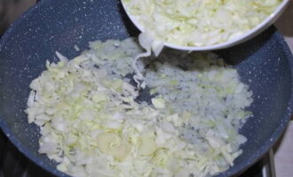 Now you can start filling. Finely chop the onion. Chop the cabbage into thin strips. First fry the onion in vegetable oil, then add the cabbage and continue frying until the latter is soft.