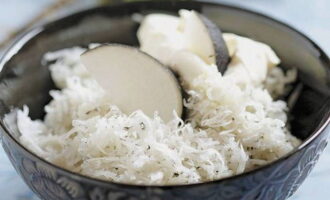 The radish is peeled and grated into shavings. 