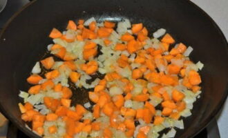 Place the frying pan on the fire, pour in the vegetable oil. When the oil is hot, add the onion and fry it for 5-7 minutes. Then add the carrots and cook for another 3-4 minutes.