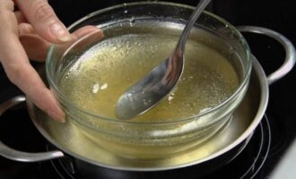 Derretir la gelatina hinchada al baño maría. Agréguelo a la masa de cuajada y mezcle nuevamente. 