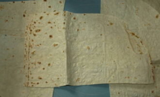 Place sheets of thin pita bread on the table and cut each into 4 pieces.