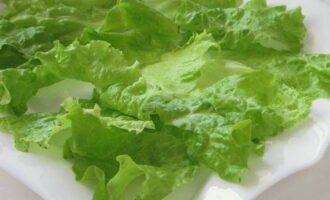 Wash the lettuce leaves, dry them, tear them with your hands and place them on a plate.