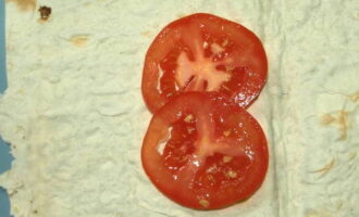 Place two mugs of tomato on each piece of pita bread.