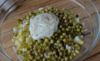 Then add canned green peas to the salad, add any mayonnaise to your taste, add salt and ground black pepper.