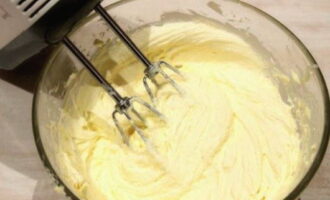 When the mass becomes homogeneous again, pour in 100 grams of condensed milk from the second can and continue whisking.