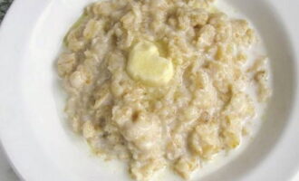 Season the oatmeal porridge with butter and serve.