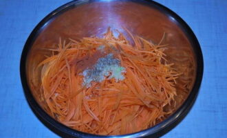 Add chopped garlic, coriander, ground red pepper and vegetable oil to the carrots, stir.