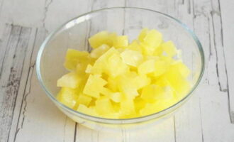 Uncork the jar of pineapples and pour the juice into a cup. You should not pour it out, as it is very sweet and tasty. To rid the pineapples of excess liquid, place them on paper towels, then carefully transfer them to a cutting board and cut them into cubes.