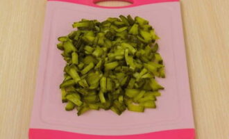 Peel the onions and, together with pickled cucumbers, also cut into strips.