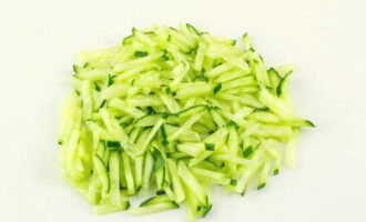 How to prepare a delicious salad with shrimp and pineapple? We start cooking by slicing a fresh cucumber directly in the peel into thin strips.